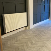 grey herringbone floor with dark panelled walls