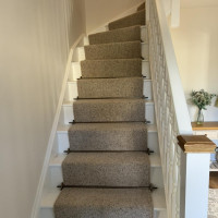White staircase and stairs with beige carpet runner